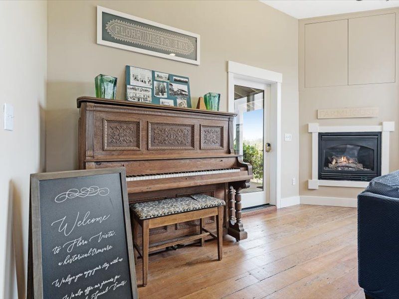 A piano is sitting in a living room next to a fireplace.