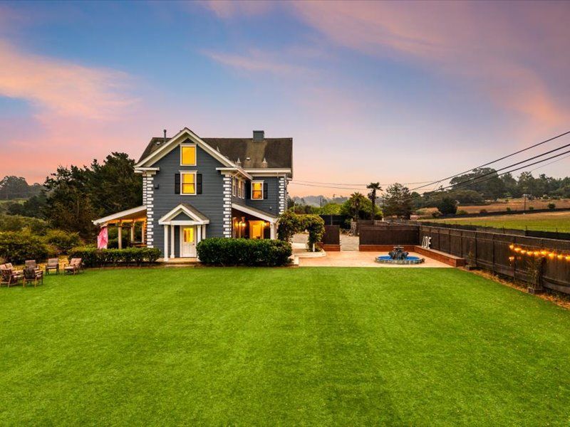 A large house with a large lawn in front of it.