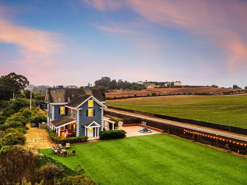 An aerial view of a house in the middle of a field.