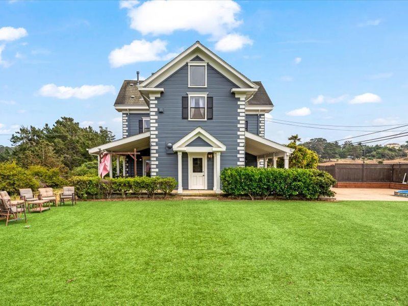 A large house with a large lawn in front of it.
