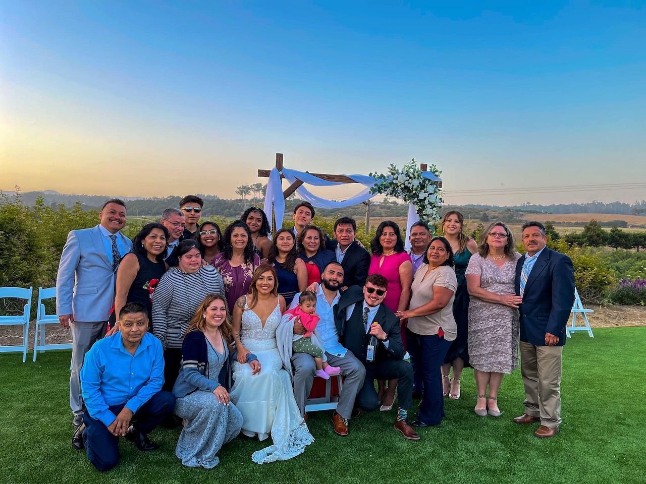 A large group of people are posing for a picture at a wedding.