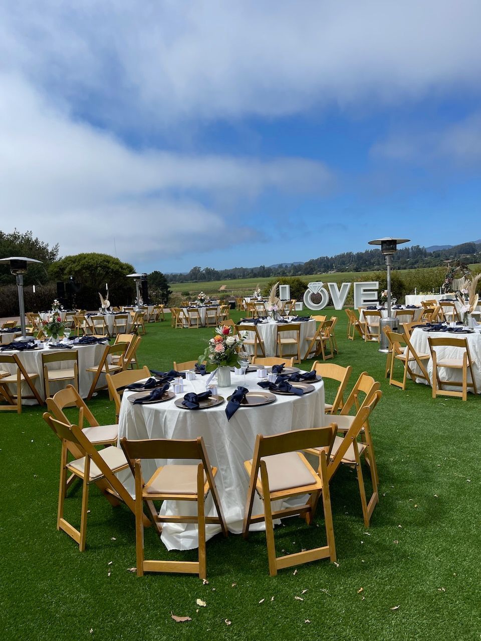 A lawn with tables and chairs set up for a wedding reception.
