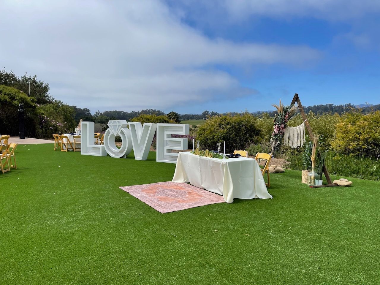 A large love sign is sitting on top of a lush green field.