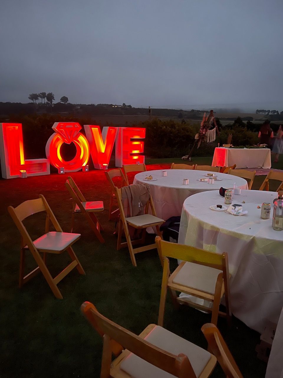 A lawn with tables and chairs and a sign that says love