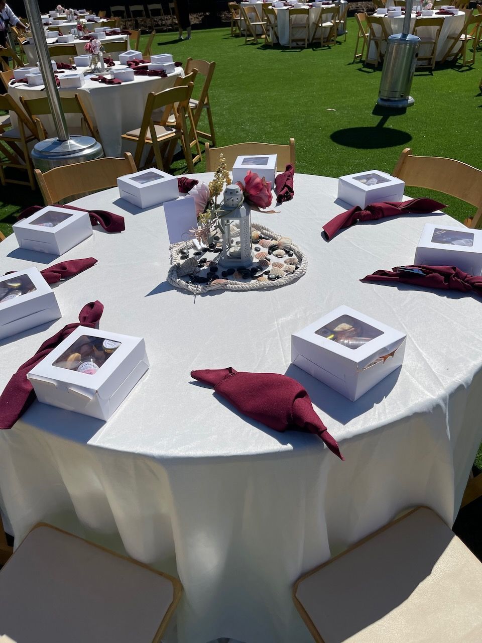 A round table with a white table cloth and boxes on it