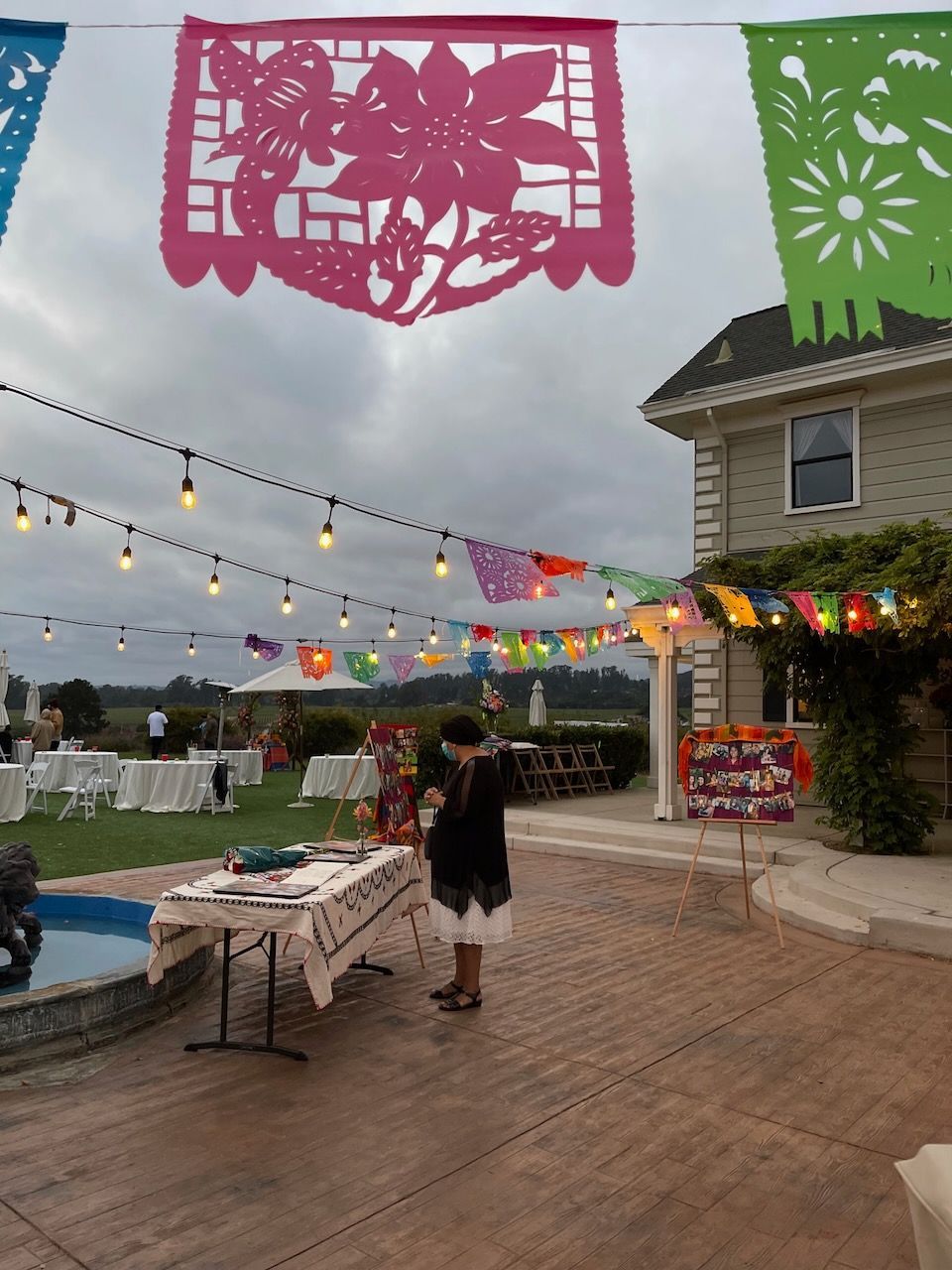 A woman stands in front of a table with paper flags hanging from it