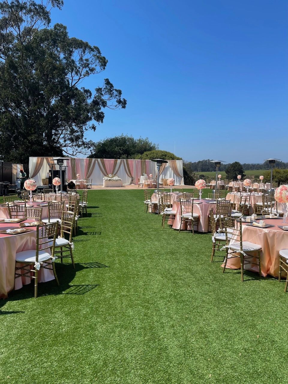 A lawn with tables and chairs set up for a wedding reception.