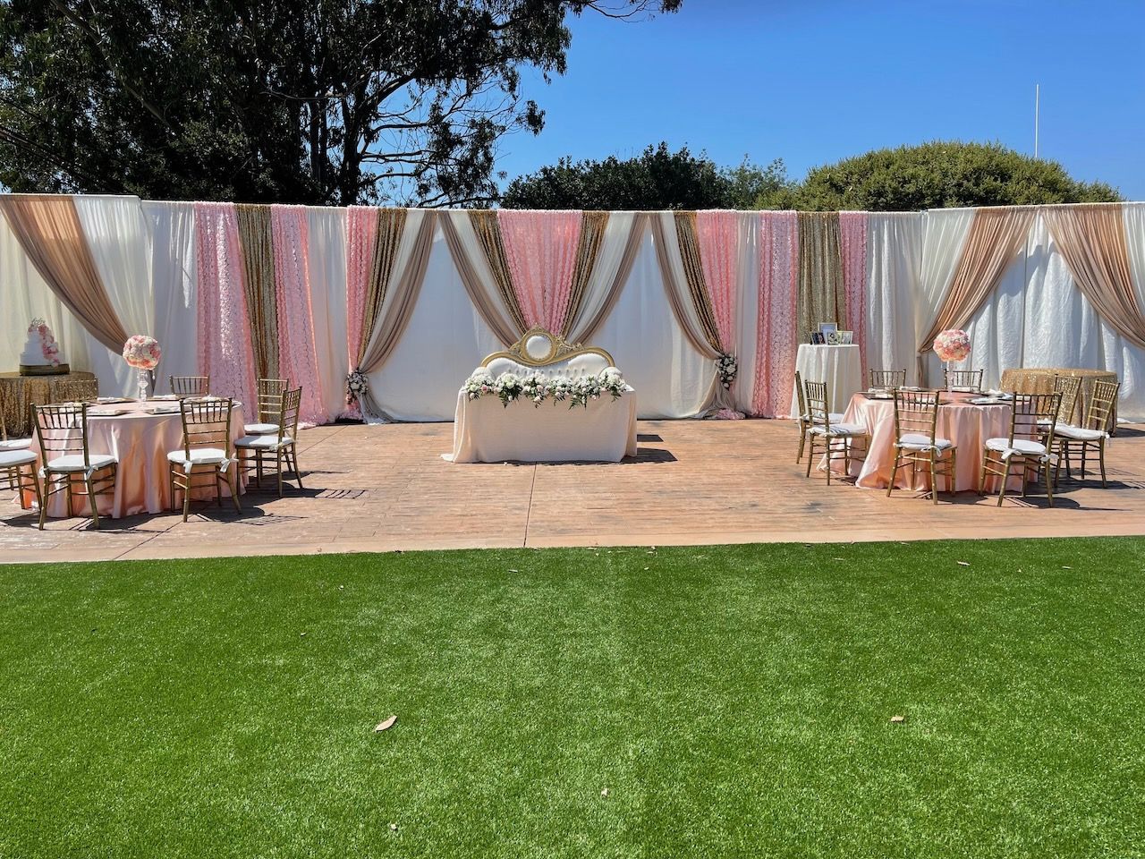 A large lawn with tables and chairs set up for a wedding reception.