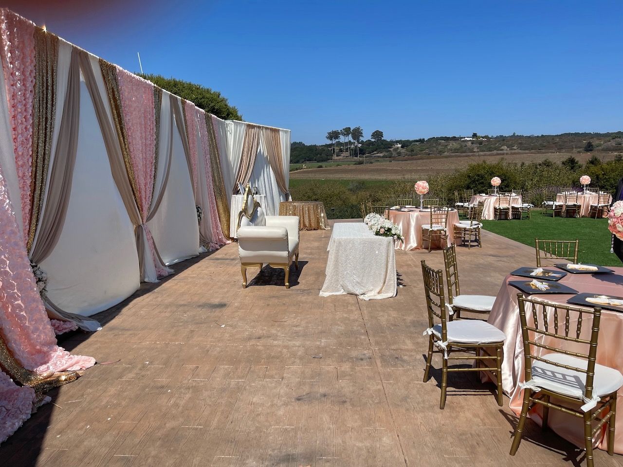 A patio with tables and chairs set up for a wedding reception.