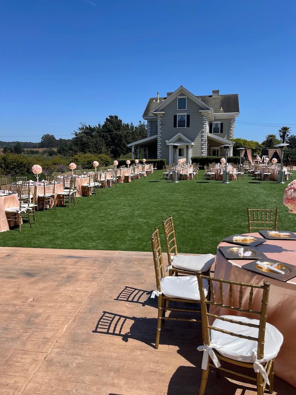 Tables and chairs are set up in front of a large house