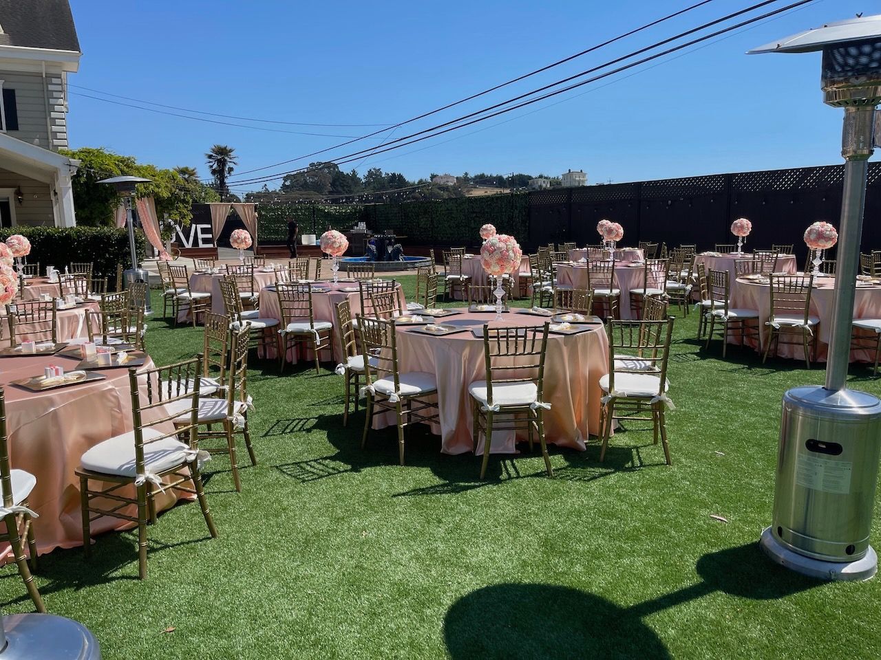 A lawn with tables and chairs set up for a wedding reception.