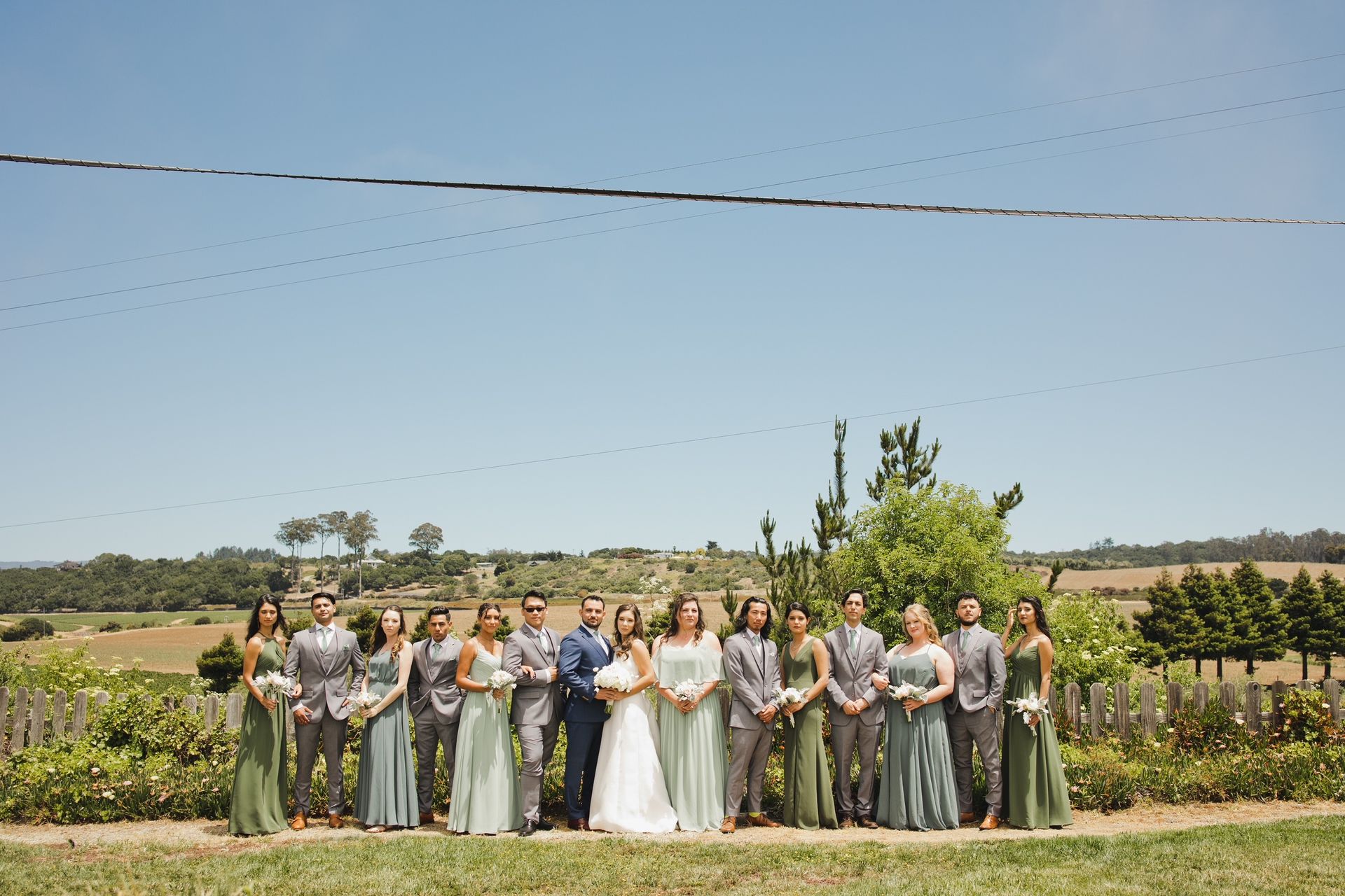 A bride and groom are posing for a picture with their wedding party.