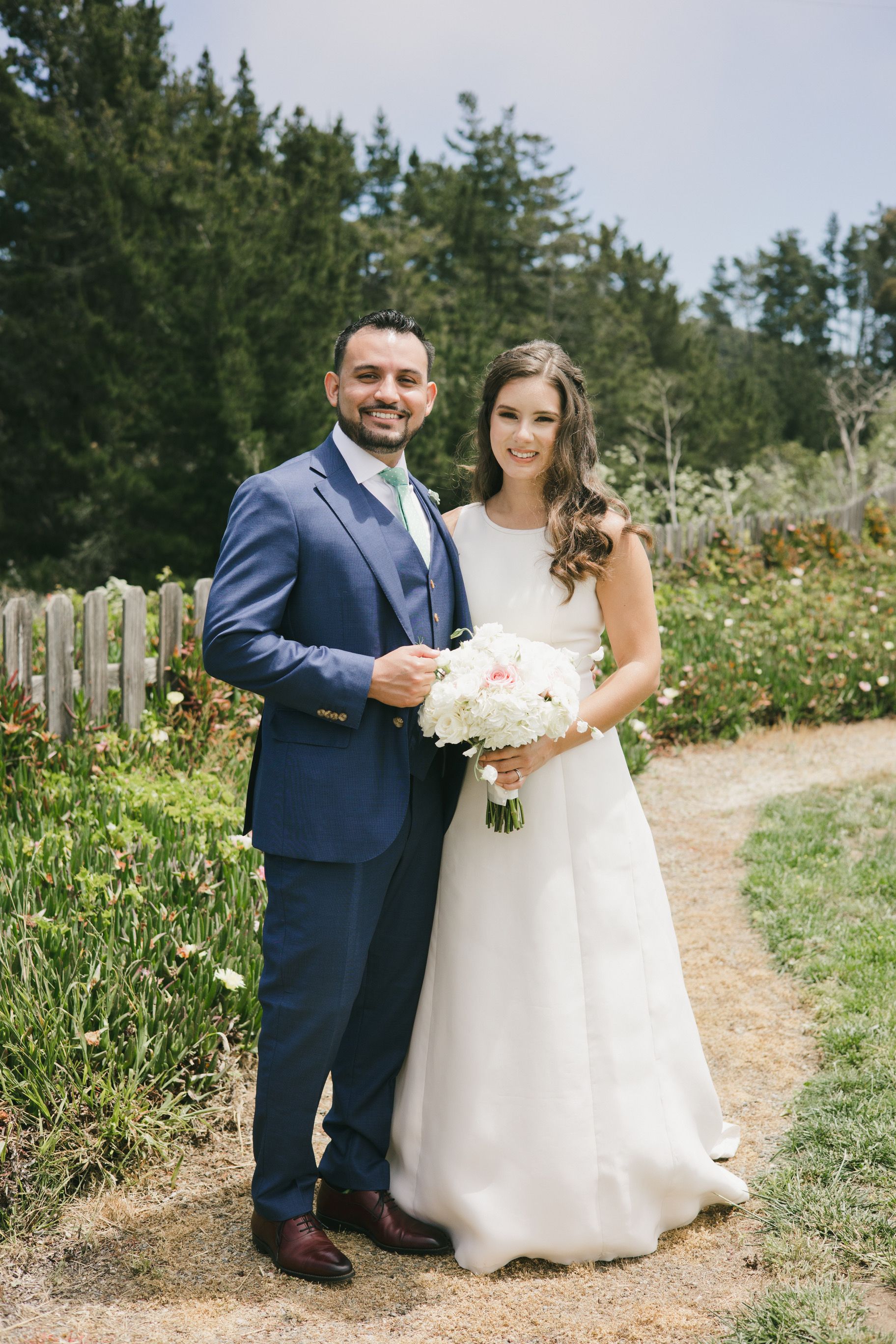 A bride and groom are posing for a picture on their wedding day.