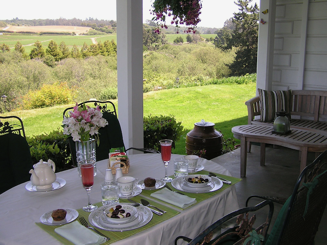 A table with plates and glasses on it on a porch