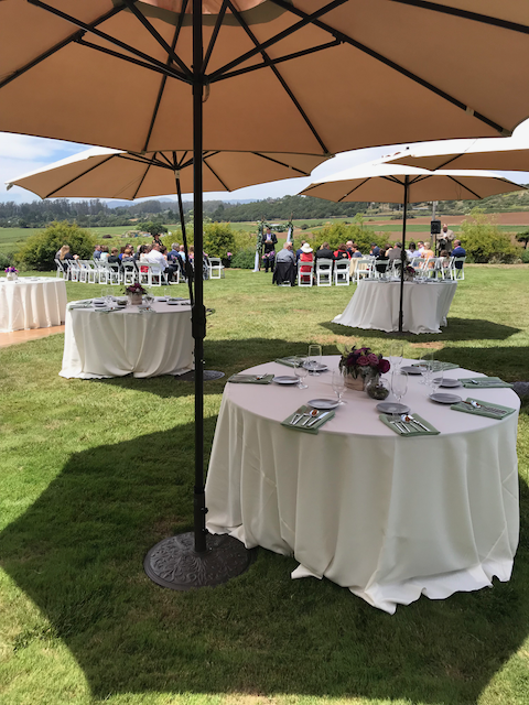 Tables and umbrellas are set up for a wedding reception