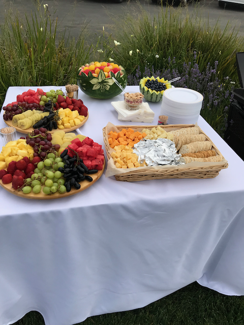A table with plates of fruit and cheese on it