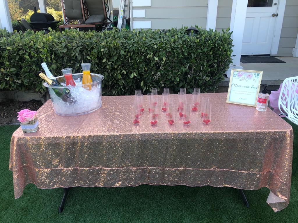 A table with glasses and a bucket of champagne on it.