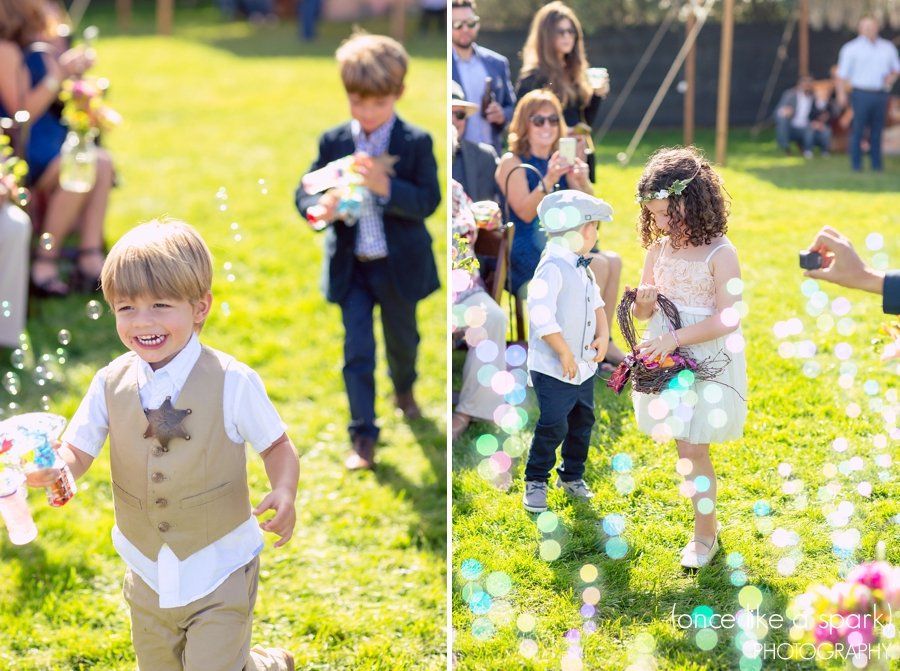 A boy and a girl are blowing bubbles at a wedding.
