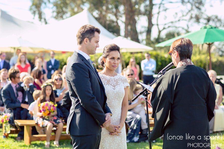 A bride and groom are standing in front of a microphone during their wedding ceremony.