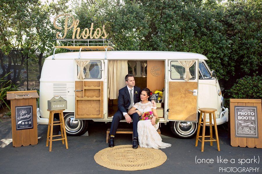 A bride and groom are sitting in a photo booth.