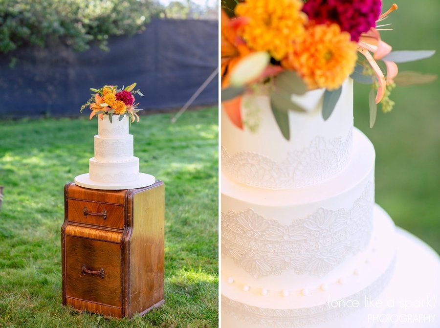 A wedding cake is sitting on top of a wooden trunk.