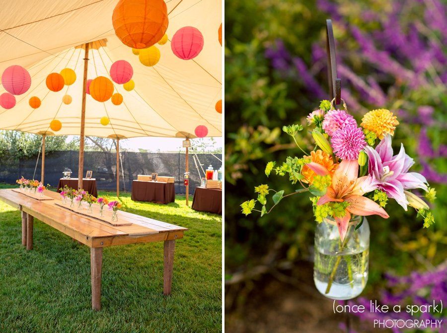 A table under a tent with lanterns and flowers