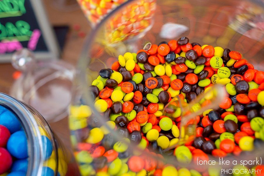 A glass jar filled with colorful m & m 's on a table.