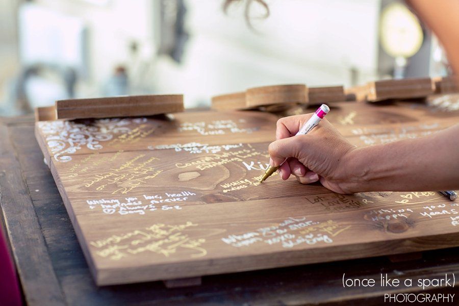 A person is writing on a wooden board with a pencil.