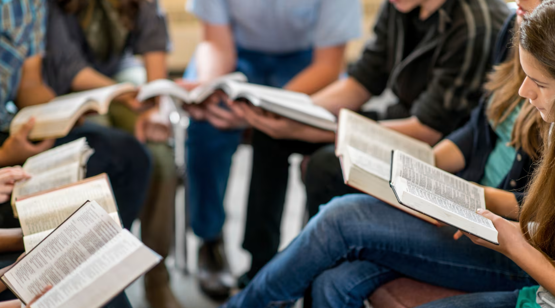 A group of people are sitting in a circle reading books.