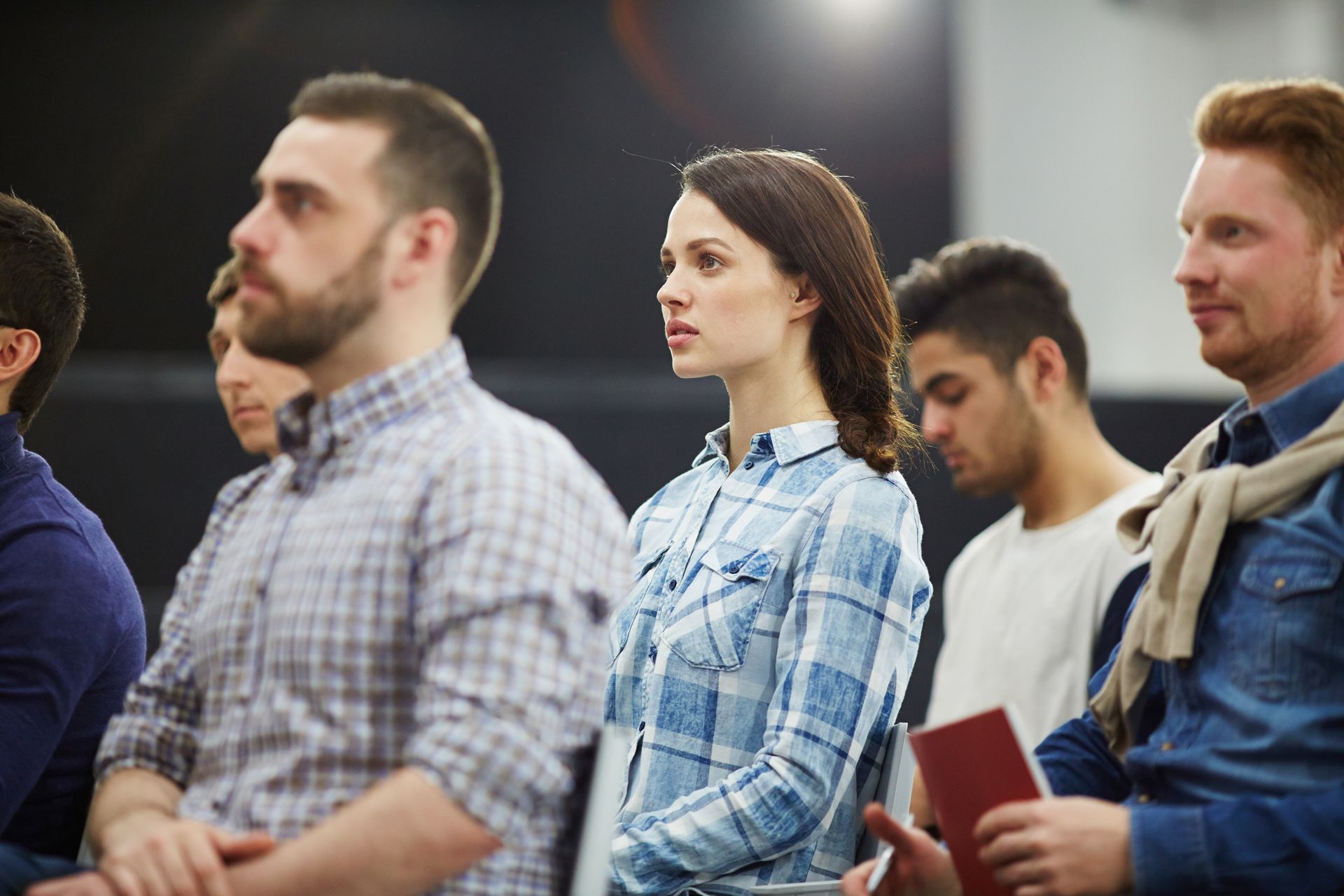 A group of people are sitting in a row in a room.
