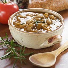 Bowl of beans with rosemary, tomato, and bread.