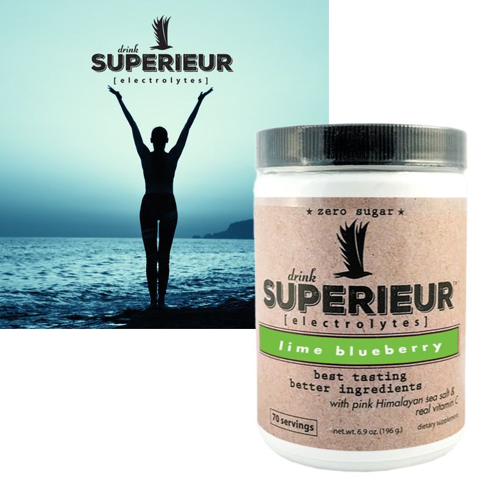 Product shot of Drink Superieur electrolyte powder in lime blueberry flavor, with a woman in a yoga pose on a beach in the background.