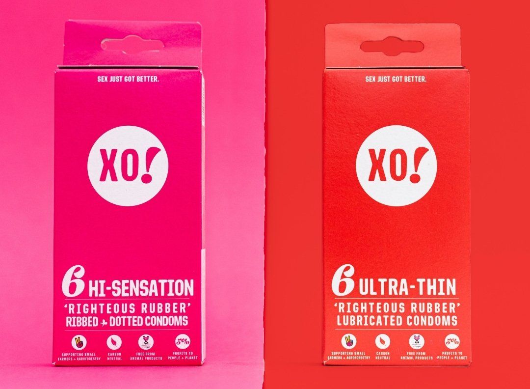 Two boxes of XO! condoms, one pink (Hi-Sensation), one red (Ultra-Thin), against respective pink and red backgrounds.