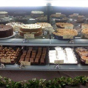 Cakes and pastries displayed in a glass bakery case.