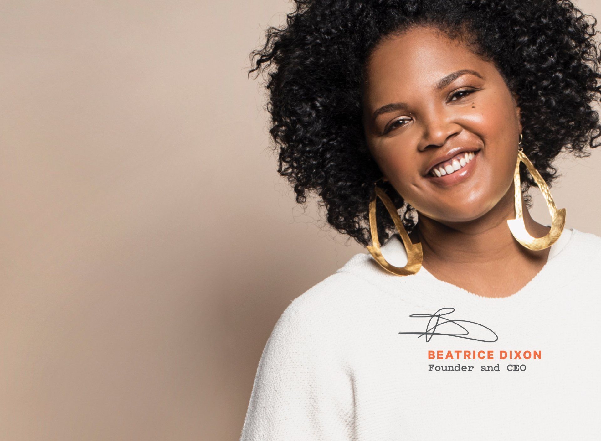 Smiling Black woman with curly hair wearing a white shirt with gold hoop earrings. Beige background.
