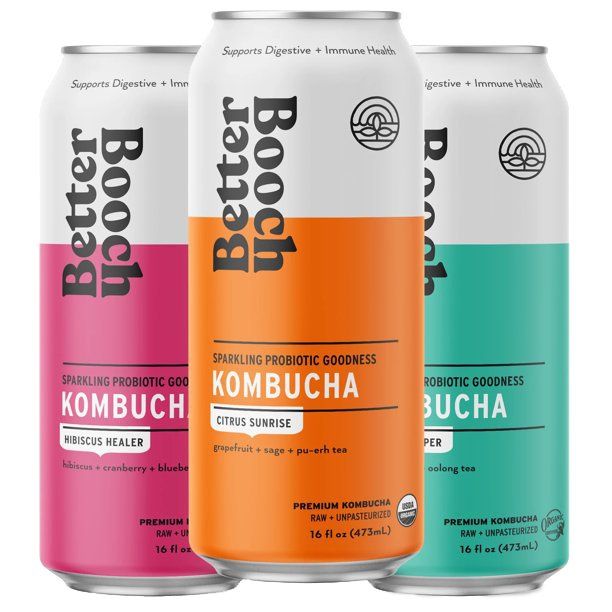 Three cans of Better Booch kombucha in hibiscus, citrus, and ginger flavors. The cans are white with colorful sections and the brand name.