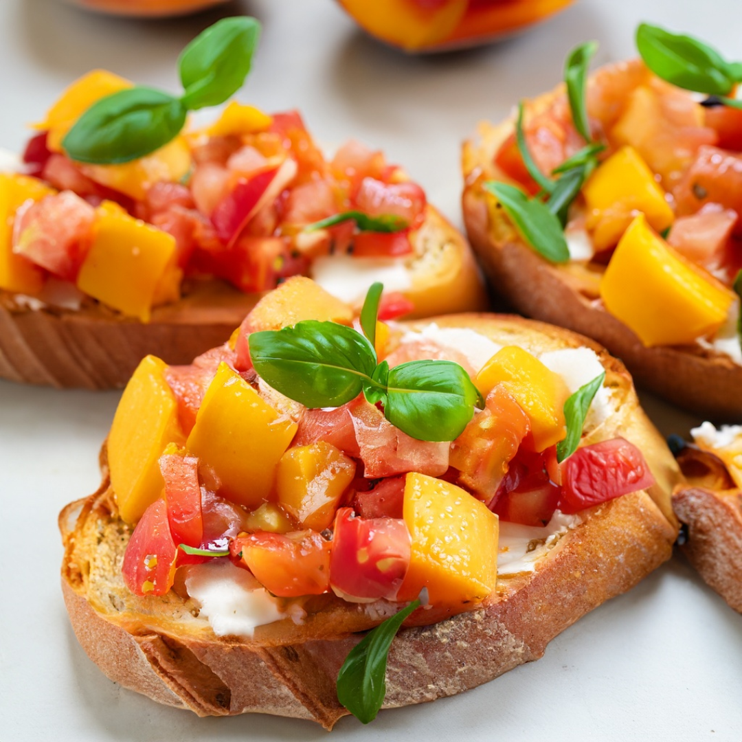 Bruschetta with diced tomatoes, peaches, and basil on toasted bread, garnished with fresh basil leaves.