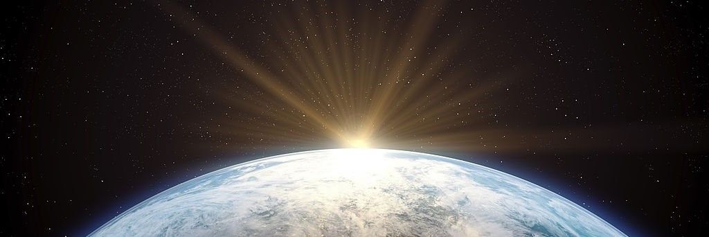 A bright light beams from beyond the edge of a pale, textured planet set against a star-filled dark backdrop.