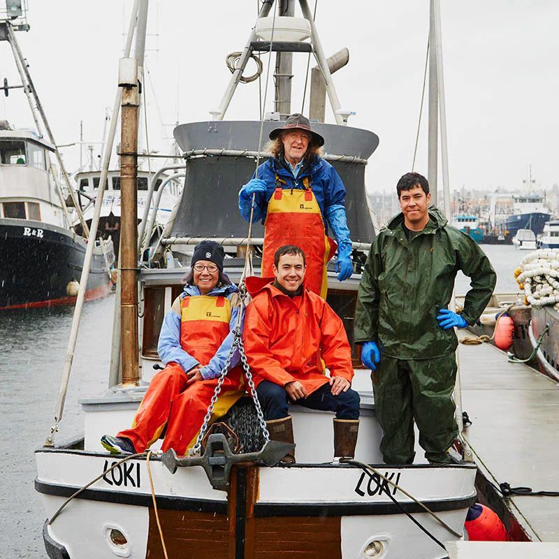 Four people on the deck of a fishing boat,