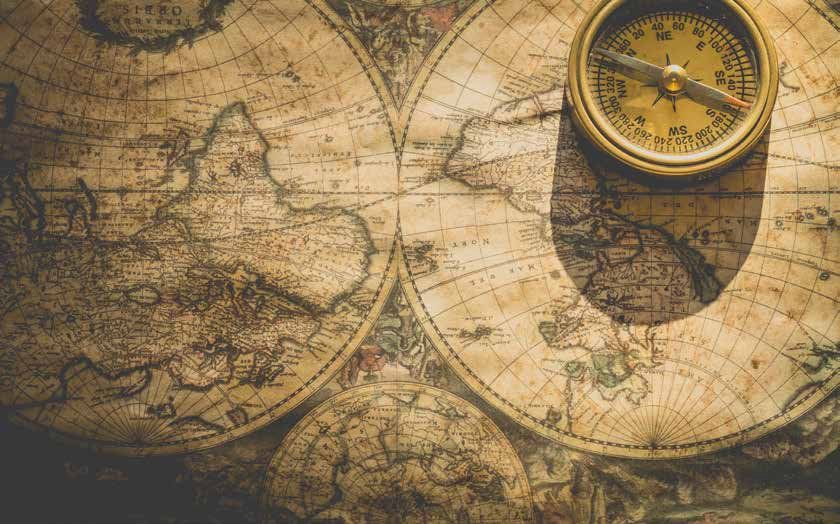 Antique map with a gold compass on top, indicating north.