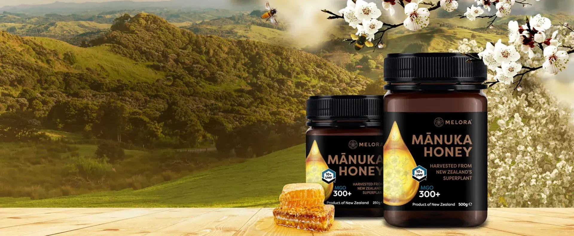 Manuka honey jars on a wooden surface, with honeycomb and a landscape background.