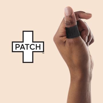 A person's hand with a black bandage on the thumb, next to the 