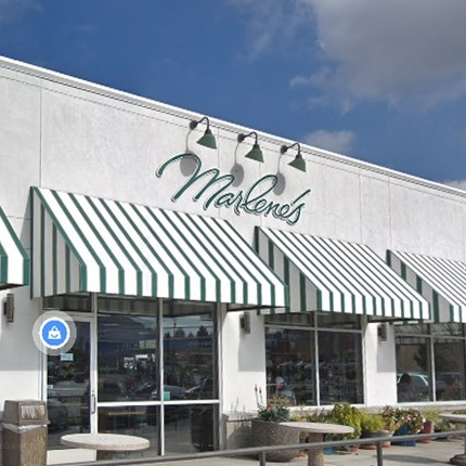 Marlene's store exterior with green and white striped awnings and signage, under a blue sky.