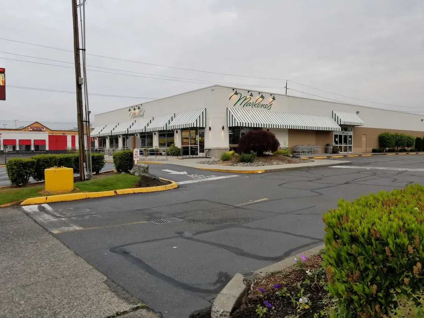 Exterior of Marino's restaurant with green and white awnings, on a cloudy day.