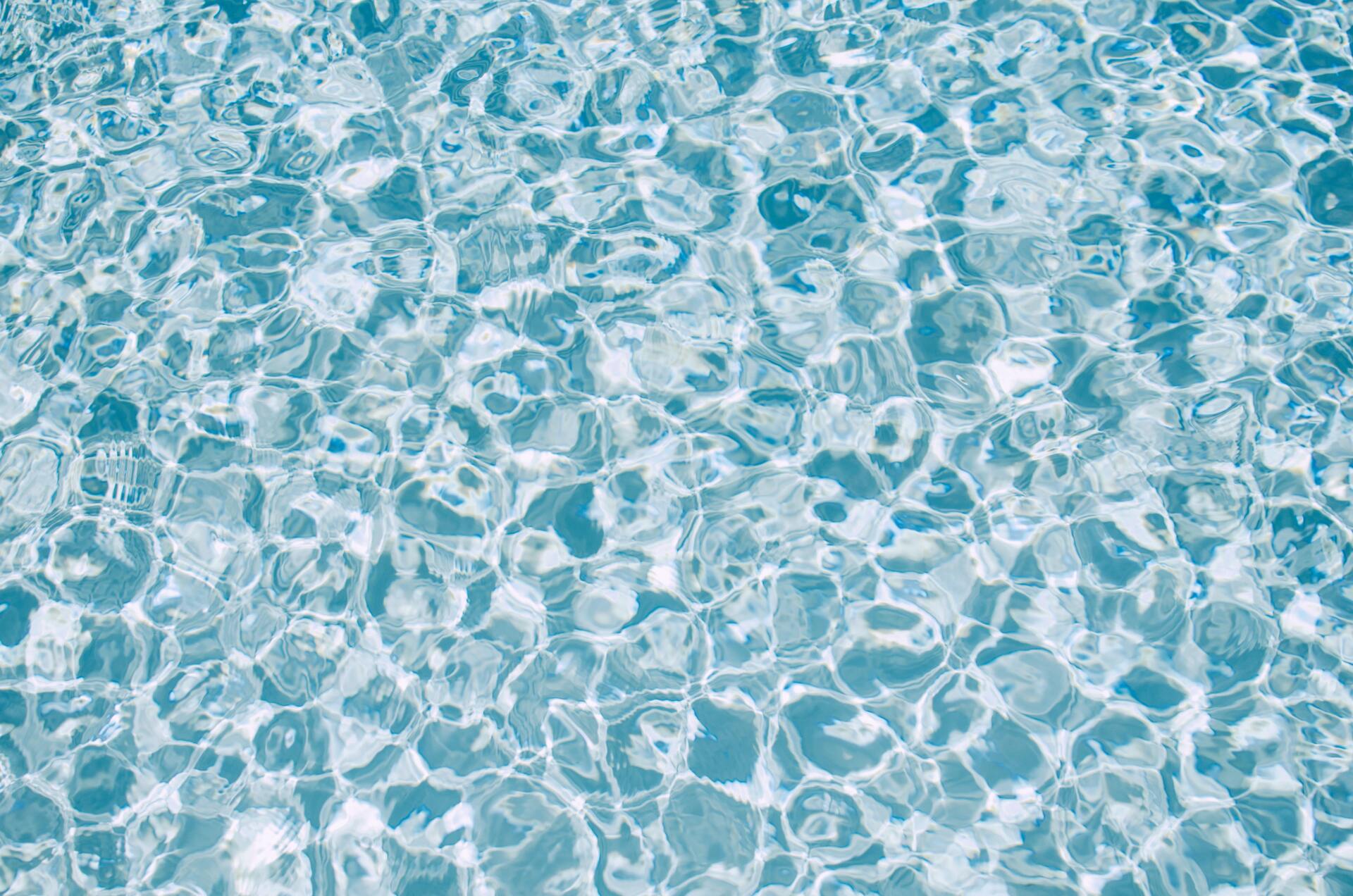 Clear, light blue water with rippling surface, reflecting light and creating a textured pattern.
