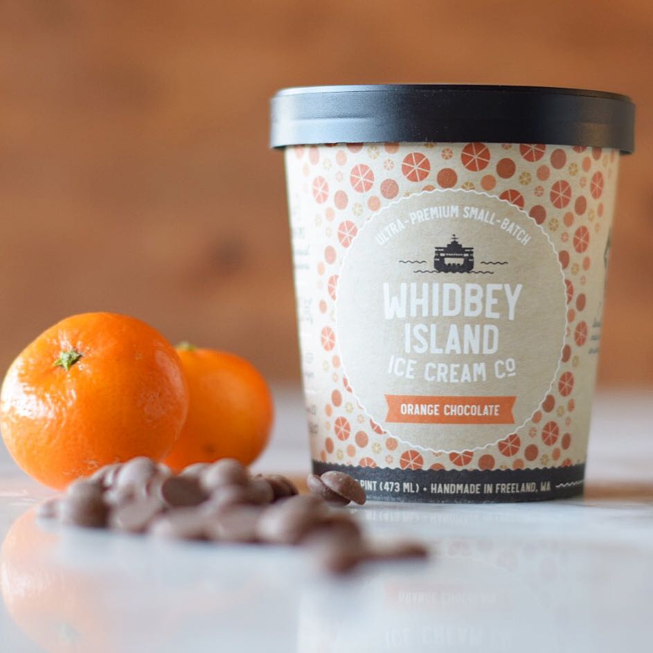 Orange chocolate ice cream from Whidbey Island Ice Cream Co. surrounded by oranges and chocolate covered candies.