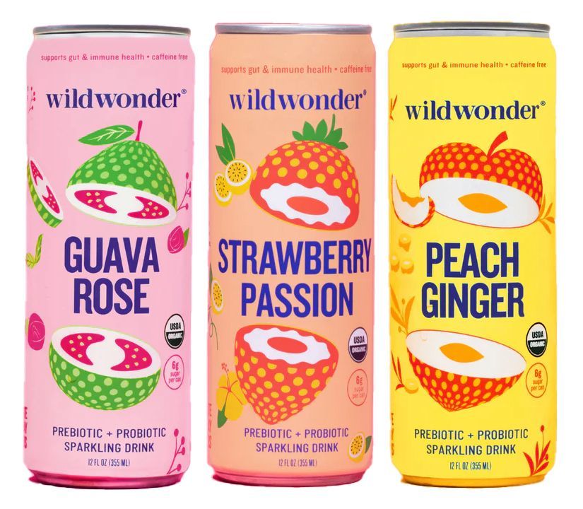 Three cans of Wildwonder sparkling drinks, featuring guava rose, strawberry passion, and peach ginger flavors. Each can is brightly colored and depicts the fruit.