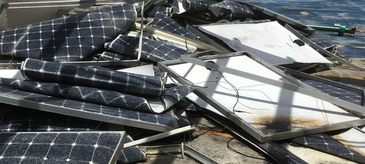 A pile of broken solar panels on the ground