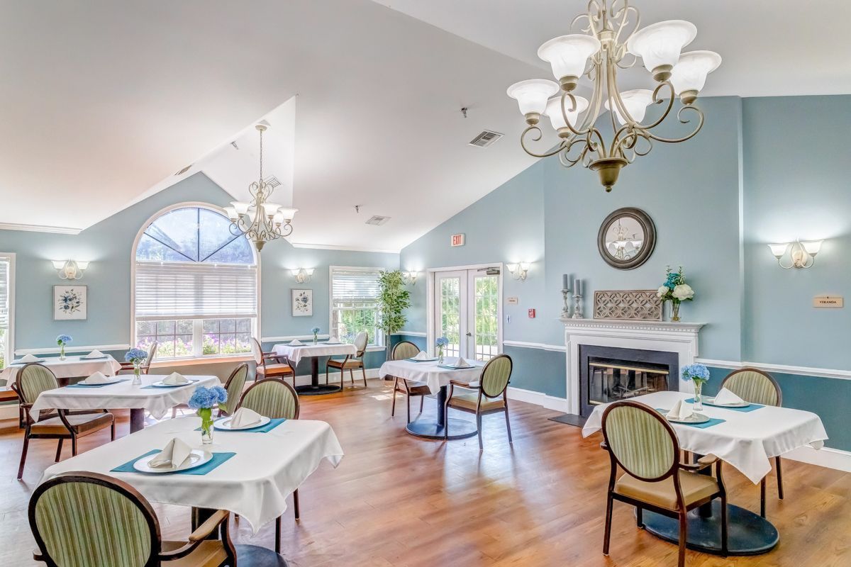 A large dining room with tables and chairs and a fireplace.