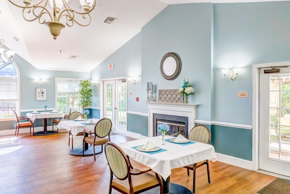 A large dining room with tables and chairs and a fireplace.